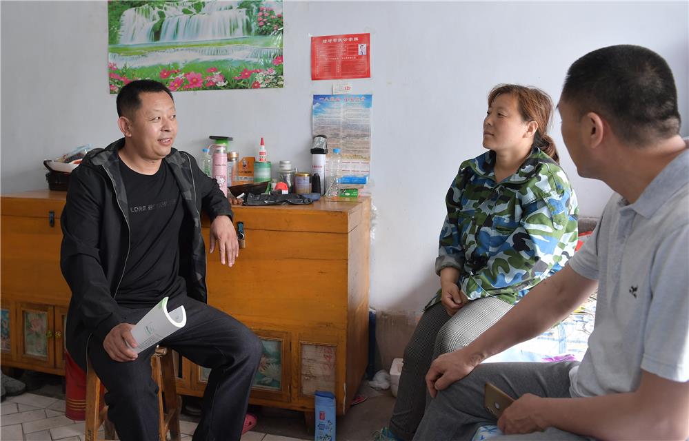 王海义(左)与村民一起研究发展旅游产业.郝振平摄