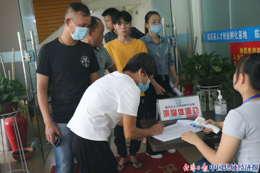 进场人员在测量体温（陈建峰 摄）