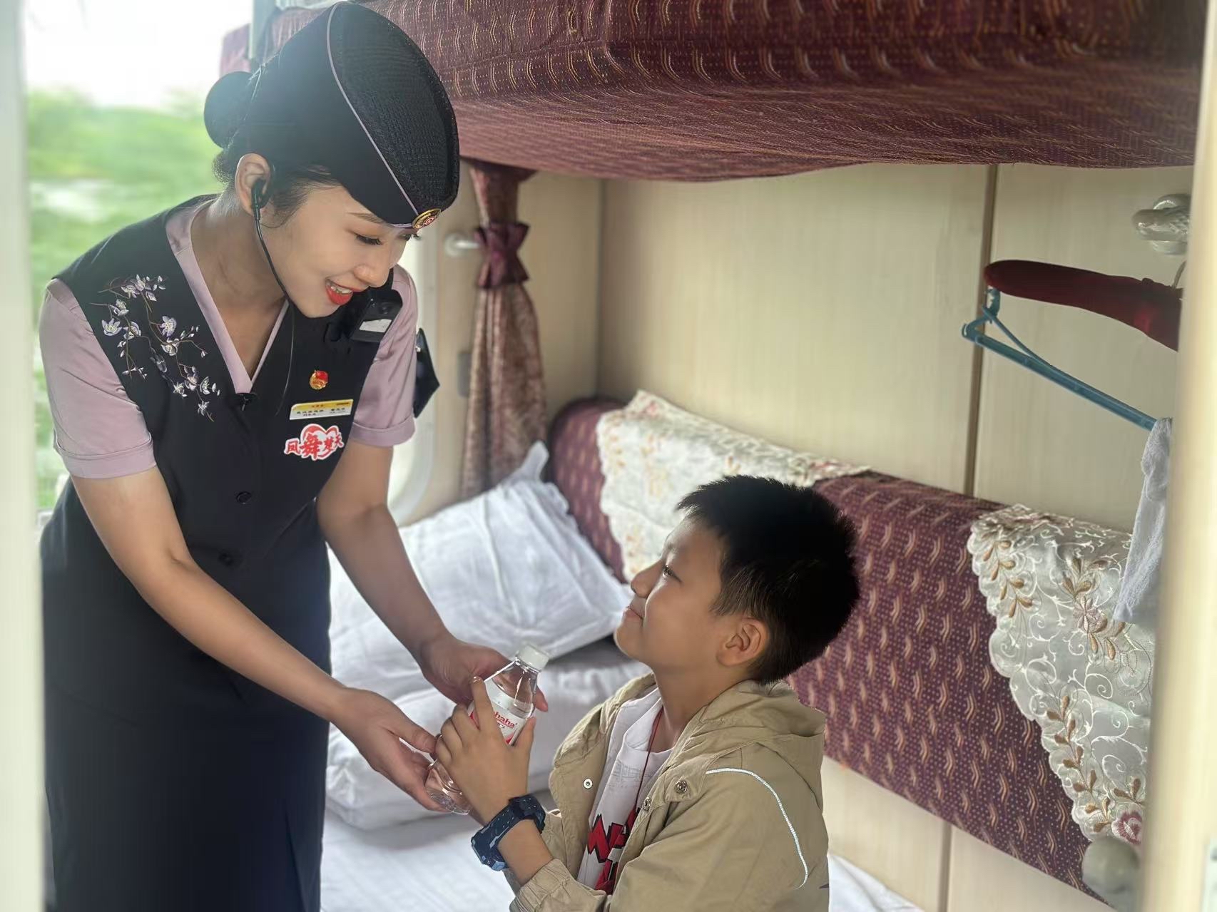 图为列车员细心服务小旅客。肖冬桂 摄