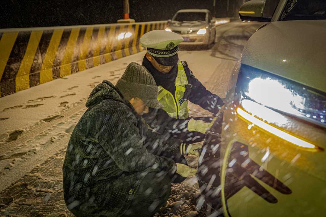 宜昌市公安局民警帮助群众安装防滑链。