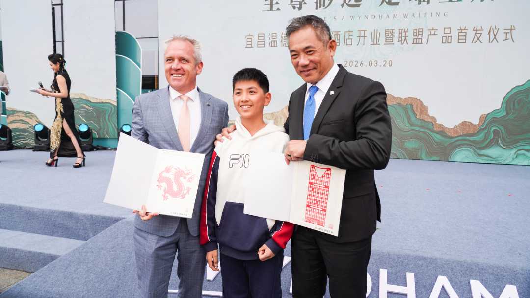 宜昌民间艺术小传人徐嘉希（中）向温德姆集团高管赠送剪纸作品。张文耀摄