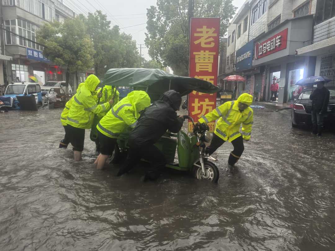 枝江警方帮助群众转移被困积水深处的车辆。
