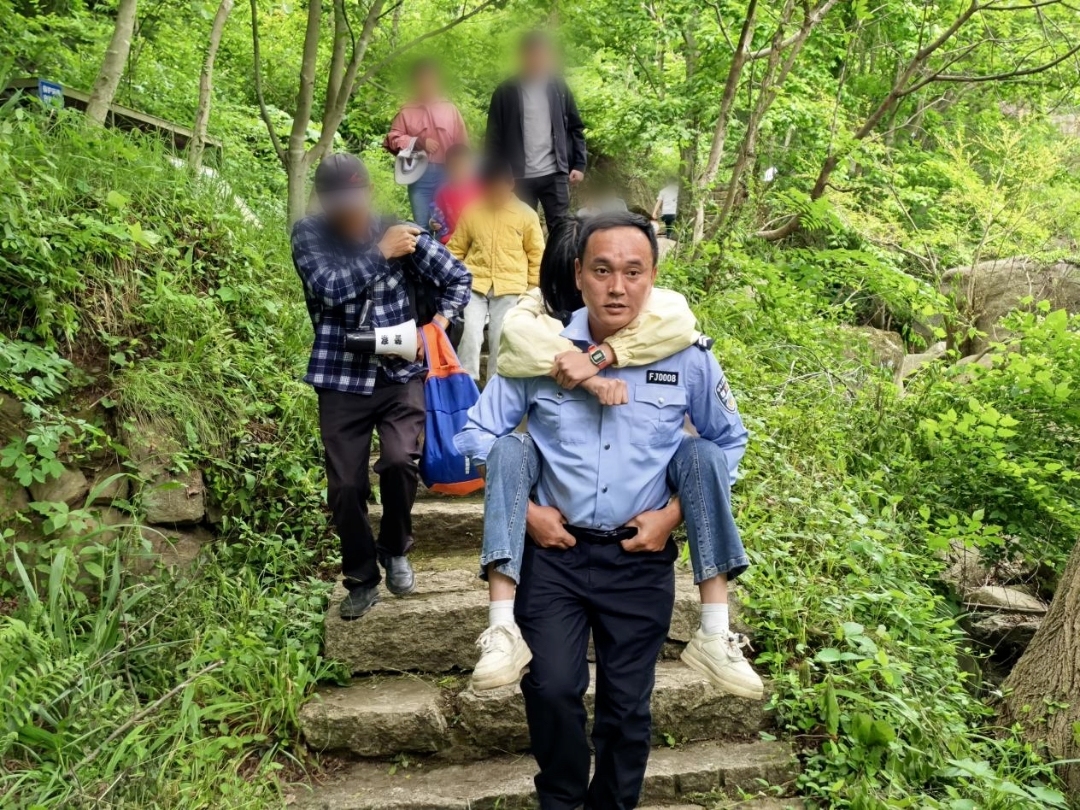 大悟县公安局民警辅警将脚踝受伤的女孩转移至安全区域，交由医护人员救治。